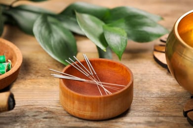 bol de bois qui contient aiguilles d'acupuncture